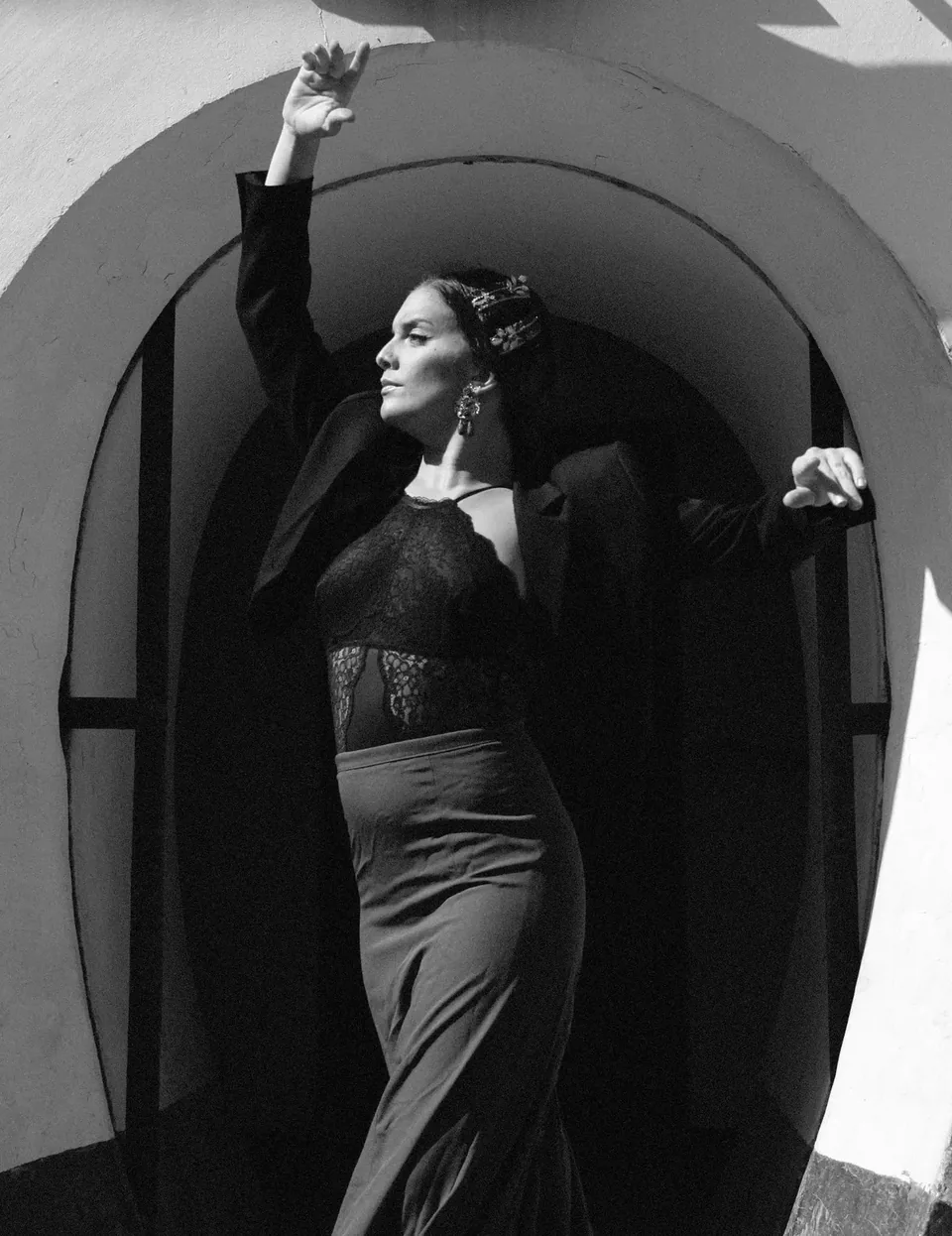 Mavi Arias bailando flamenco bajo un arco blanco, fotografía en blanco y negro